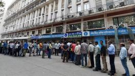 People queue up at out side of banks ATM to get money in New Delhi. 