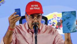 Venezuelan President Nicolás Maduro holds up "El Libro Azul", a text about the birth and development of the Bolivarian Revolution in Venezuela, and a copy of the Venezuelan Constitution. Photo: Nicolás Maduro