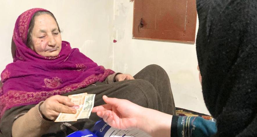 Rubeena helps out one of the women in her village with paperwork (Photo sourced by Arsalan Bhukari, 101Reporters).