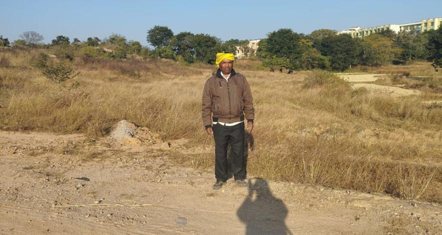 Ratan Lal showing lands whose paths were obstructed due to the boundary built by the Central University of Jharkhand (Photo - Nisha Kumari, 101Reporters).
