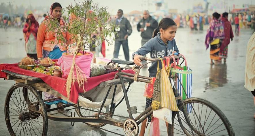 Young girl carrying puja materials for sale (Photo - Biswanath Maiti)
