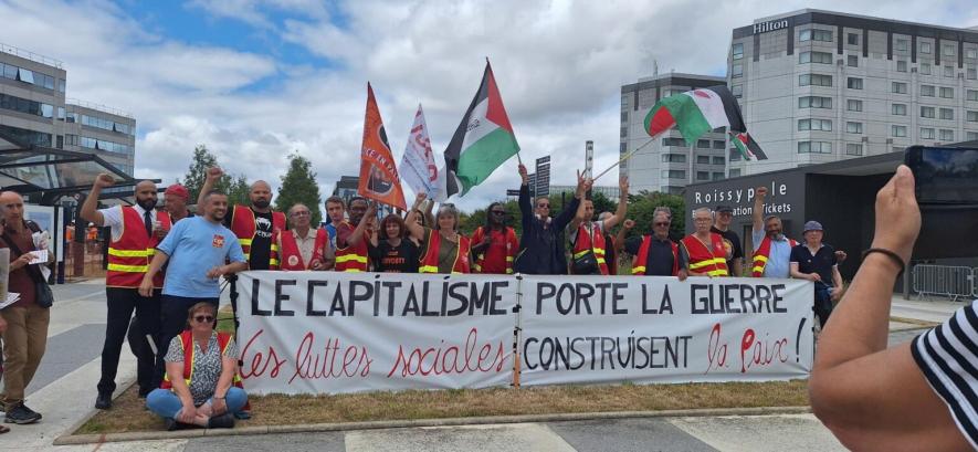 "Capitalism brings war, popular struggles build peace." Solidarity action with workers at Paris airport, June 2025. Source: BDS France-Paris/Facebook