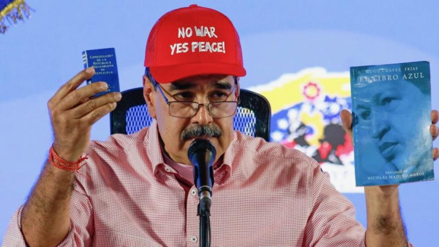 Venezuelan President Nicolás Maduro holds up "El Libro Azul", a text about the birth and development of the Bolivarian Revolution in Venezuela, and a copy of the Venezuelan Constitution. Photo: Nicolás Maduro